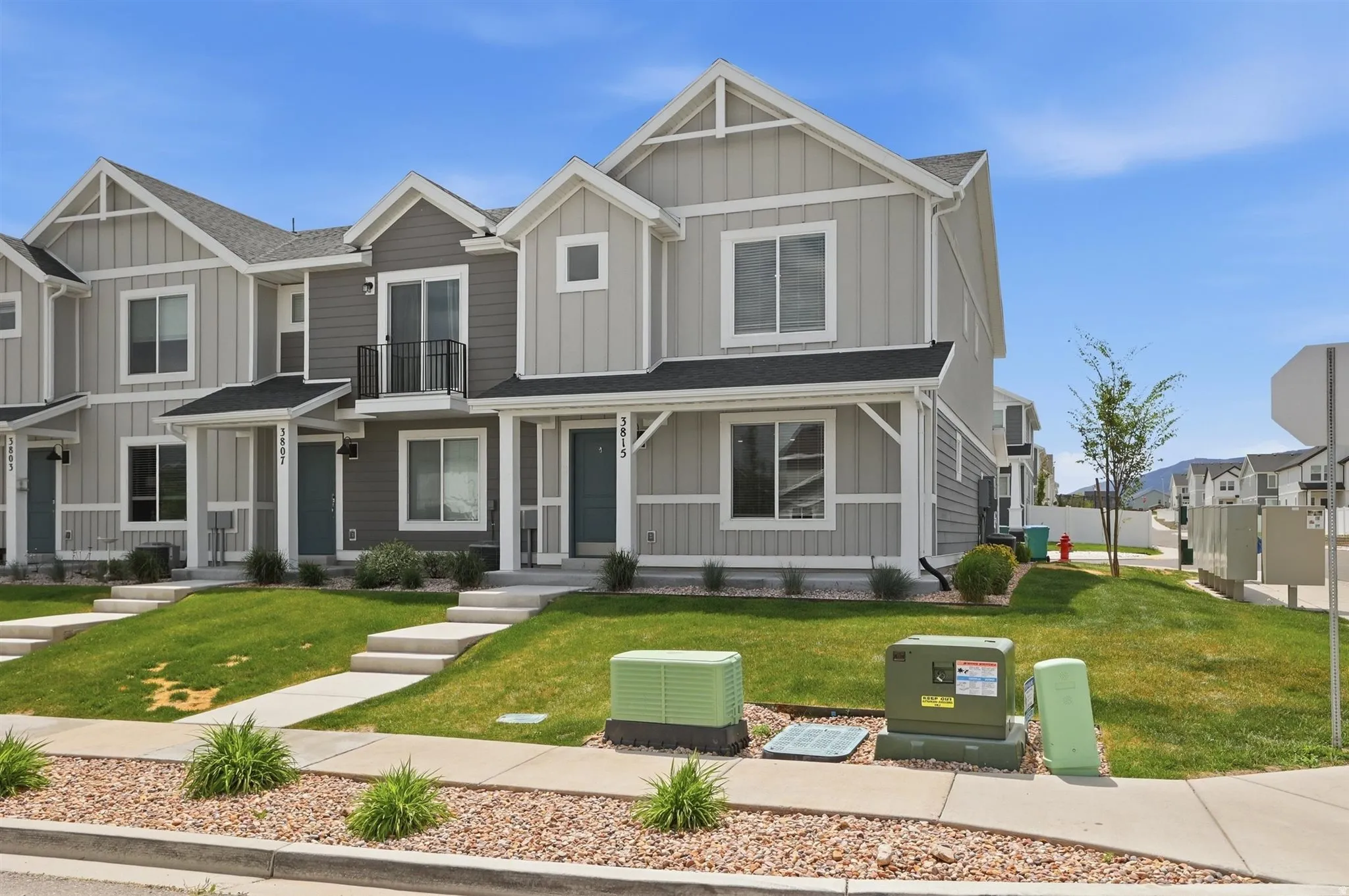 Modern townhome exterior featuring light gray vertical siding and dark gray horizontal siding accents