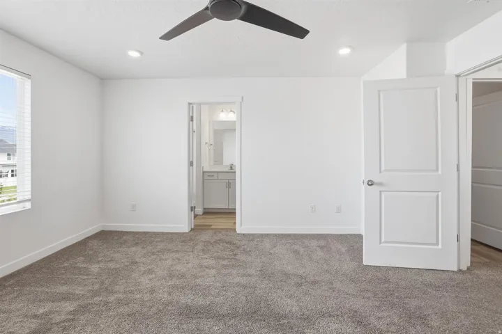 Carpeted room featuring a ceiling fan, recessed lighting, and a window with blinds