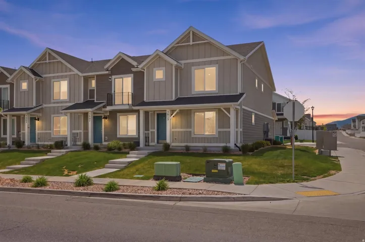 Contemporary townhomes featuring a multi-tone facade, gabled roofs, and manicured lawns