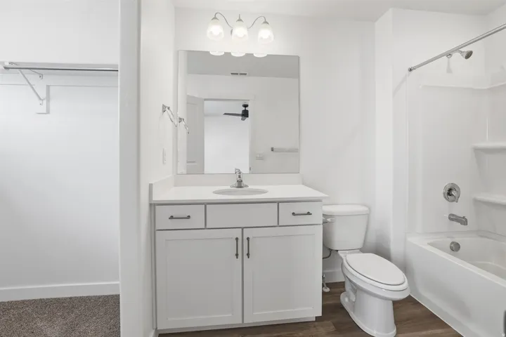Bathroom featuring a white vanity with a light countertop, integrated sink, and brushed nickel hardware
