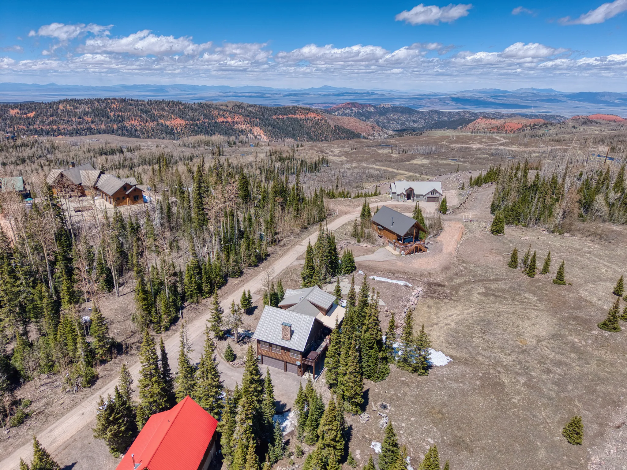 Aerial perspective showcasing multiple mountain residences amidst a dense forest landscape