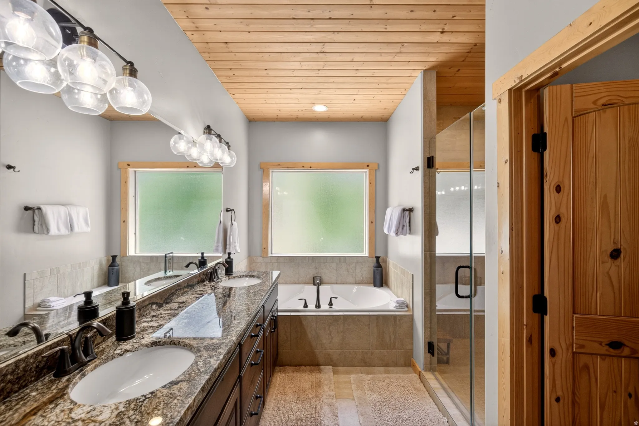 Bathroom featuring a dual vanity with undermount sinks and a stone countertop