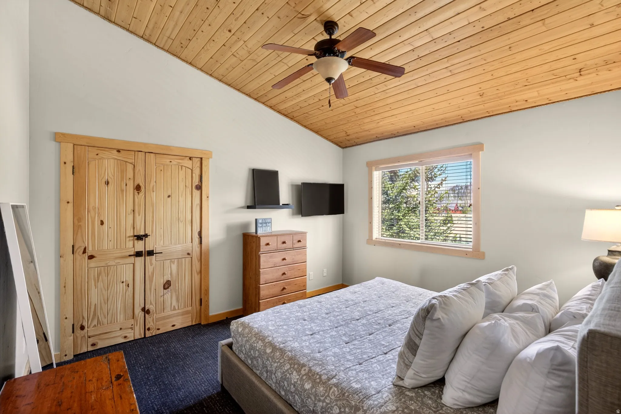 Vaulted wood-paneled ceiling with a ceiling fan
