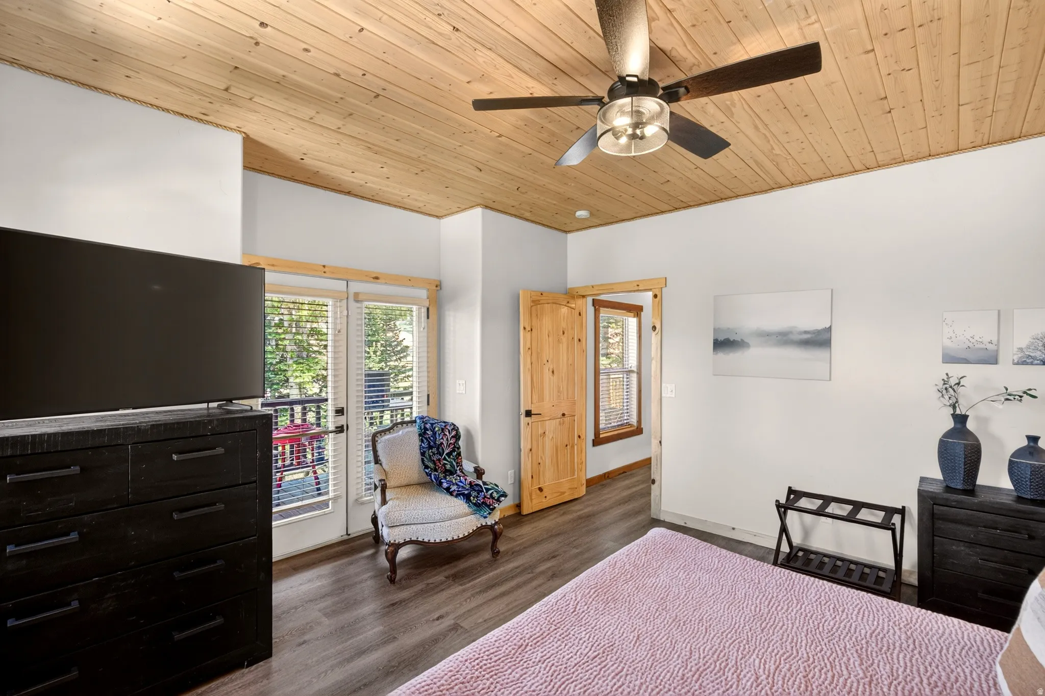 Wood-paneled ceiling with a ceiling fan, wood-finish flooring, and a private balcony with double glass doors
