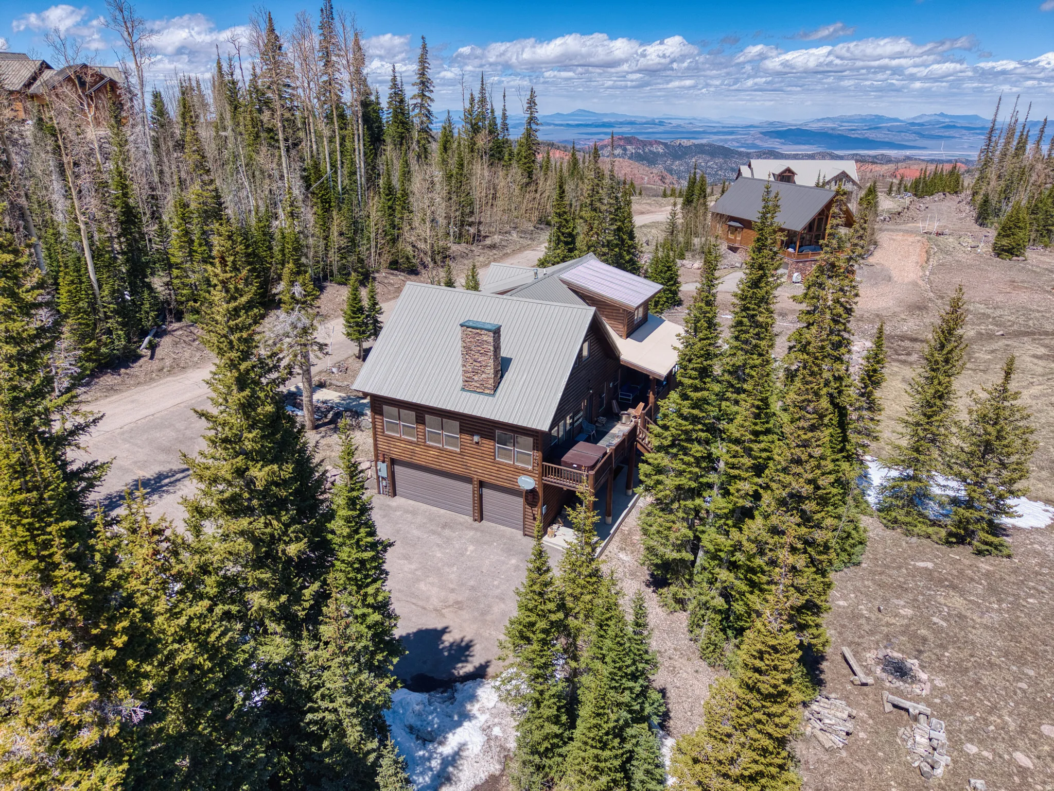 Wood-sided residence featuring a metal roof and stone chimney