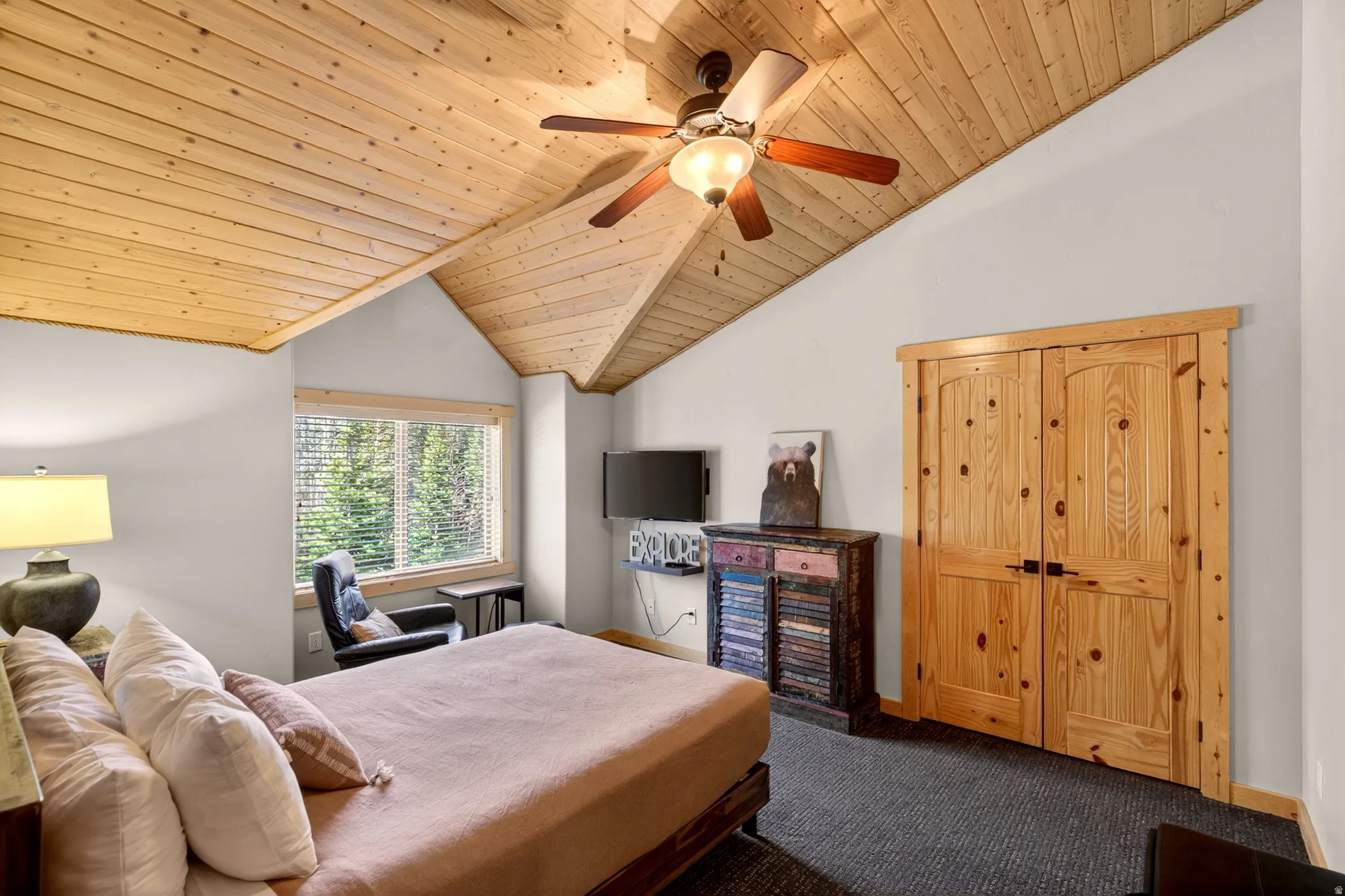 Vaulted wood-paneled ceiling with a ceiling fan