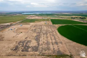 Expansive agricultural land with a large circular irrigated field, cultivated fields, and open terrain