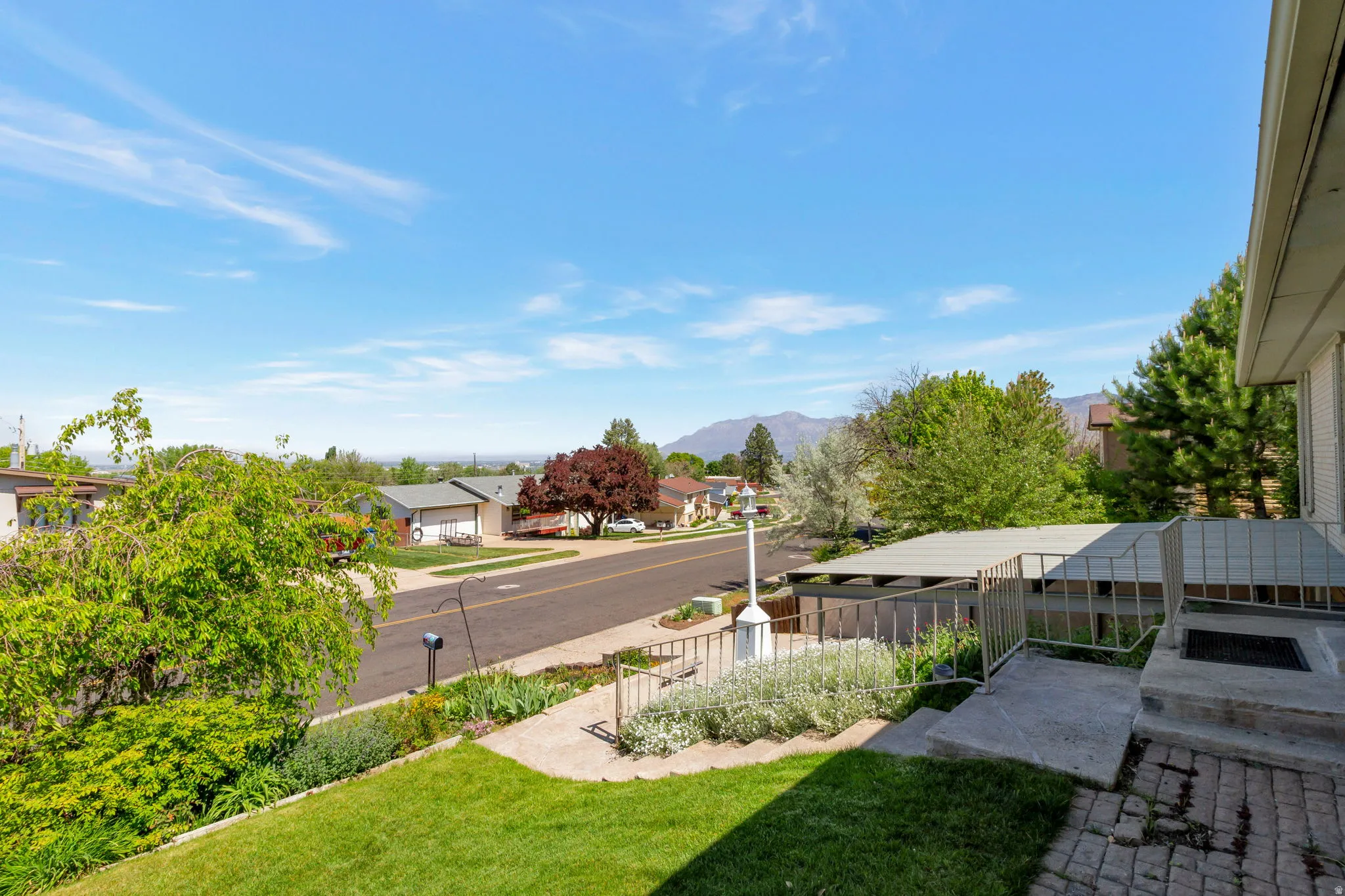 Front entrance with paver landing, metal railing, and covered carport, fantastic views