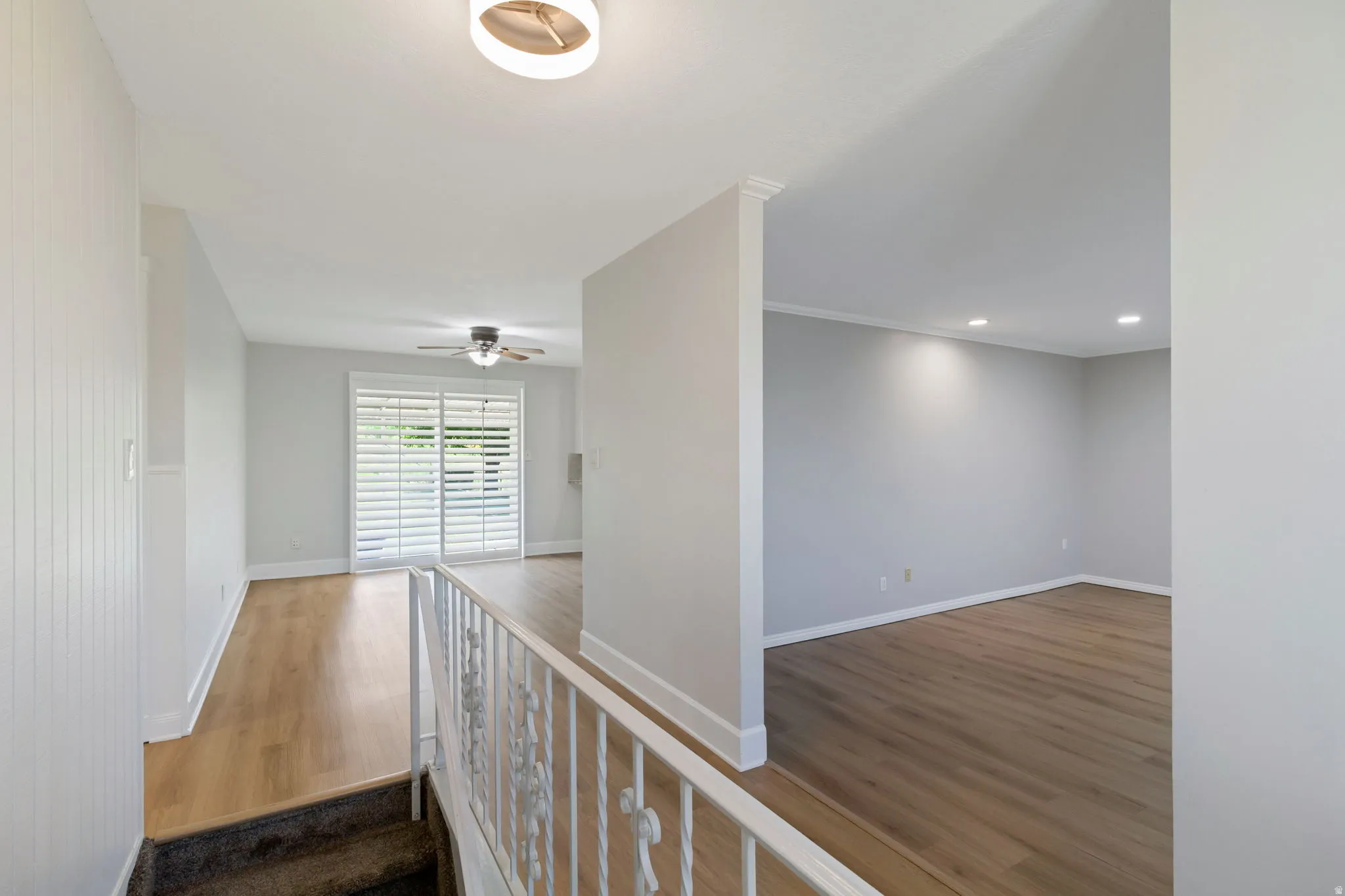 Interior featuring wood-look flooring, white plantation shutters, a ceiling fan, recessed lighting, and a contemporary ceiling fixture