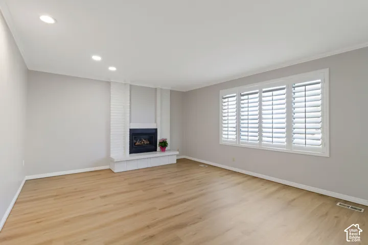 Living area featuring wood-look flooring and a white brick fireplace with a dark firebox
