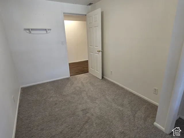 Neutral tone wall paint, carpeted flooring, white trim, and a white interior door