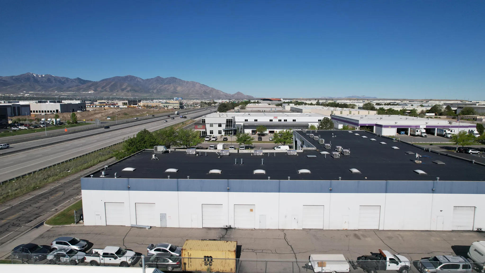Industrial building with multiple roll-up doors and a dark-colored roof