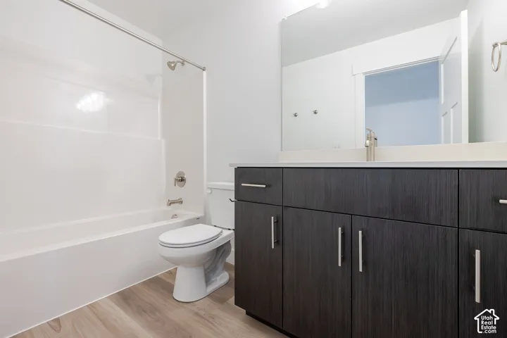 Contemporary bathroom featuring a dark wood-finish vanity with multiple storage drawers and brushed nickel hardware, white porcelain vessel sink, and a large framed mirror with integrated lighting