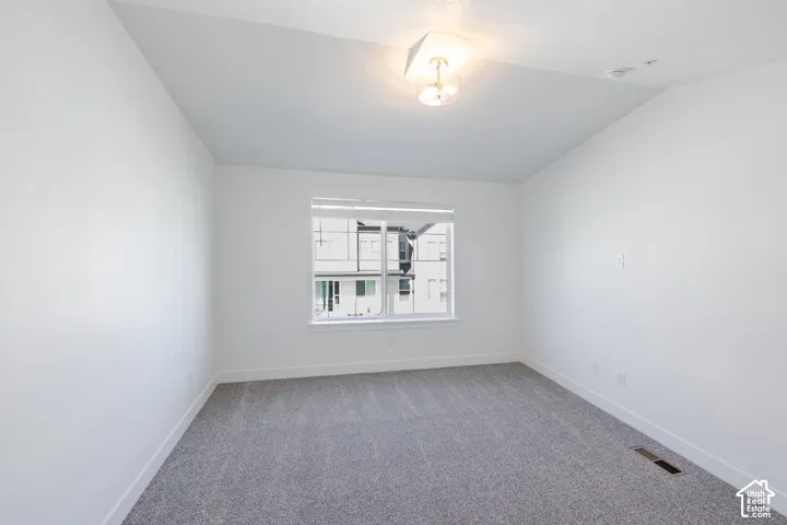 Neutral white wall paint, gray carpet flooring, window with blinds, and flush mount lighting