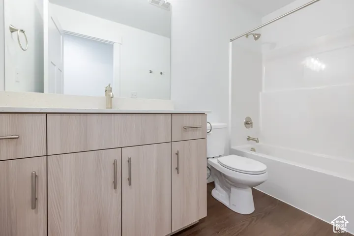 Wood-finish flooring with a white bathtub and shower combination
