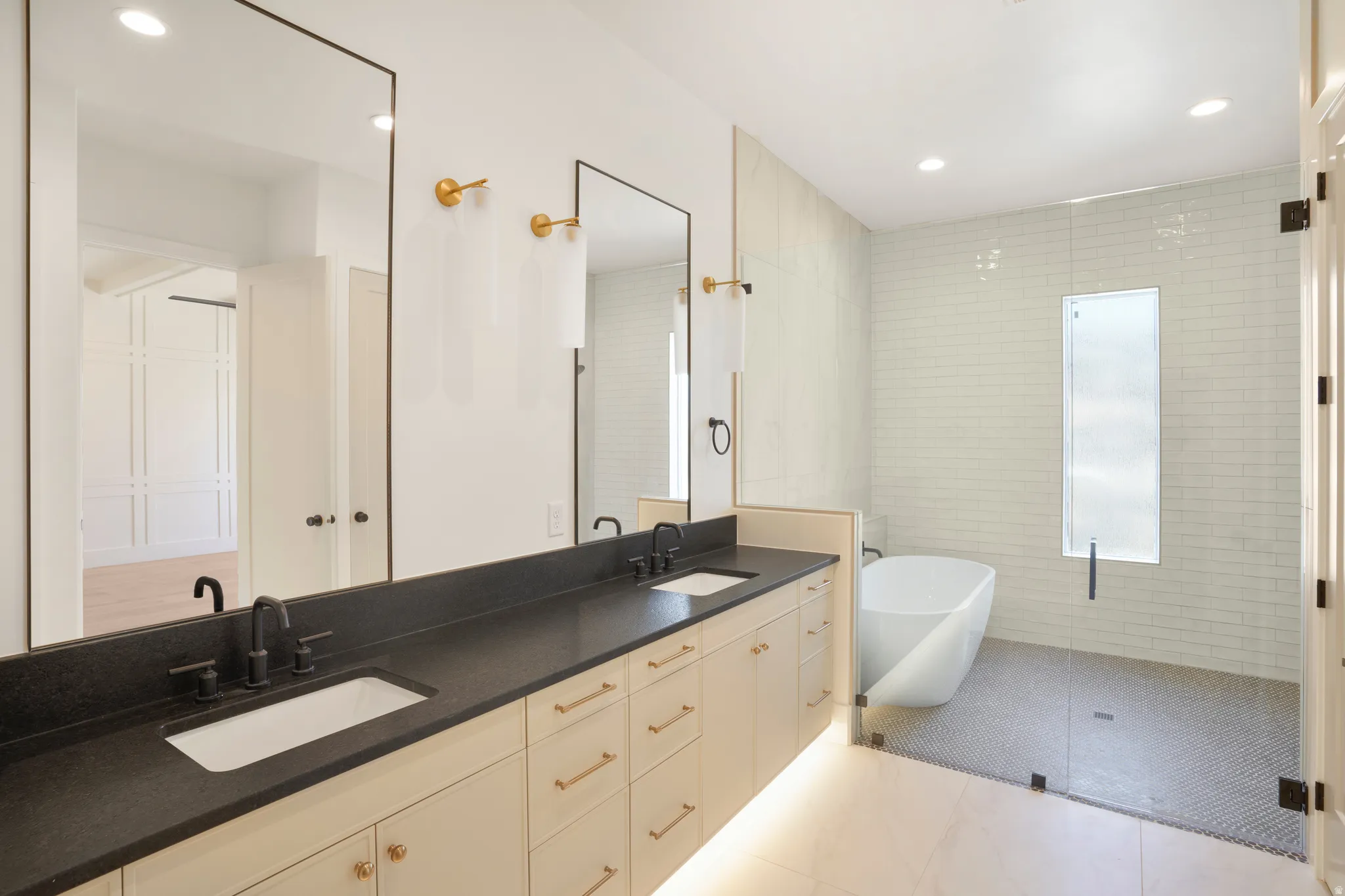 Dual sink vanity with dark countertop and gold-toned hardware