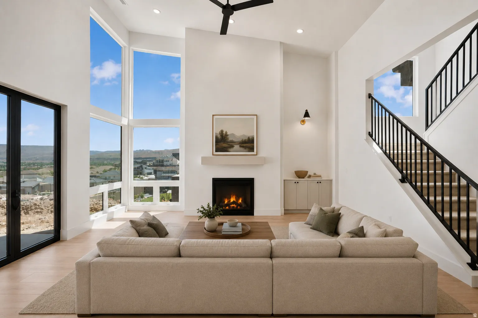 Two-story living area featuring extensive window walls, recessed lighting, and a modern ceiling fan