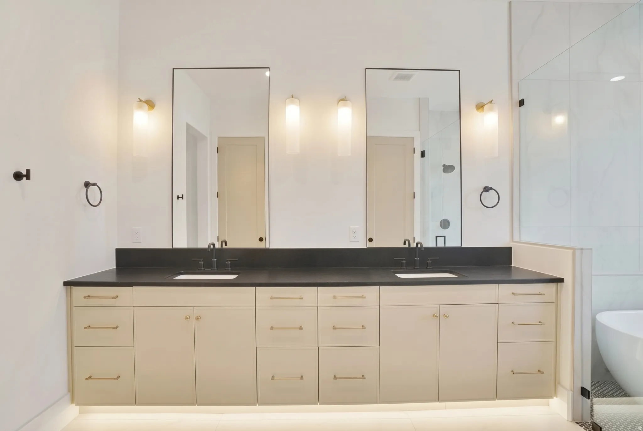 Double vanity featuring two rectangular sinks, dark countertops, and matte black fixtures