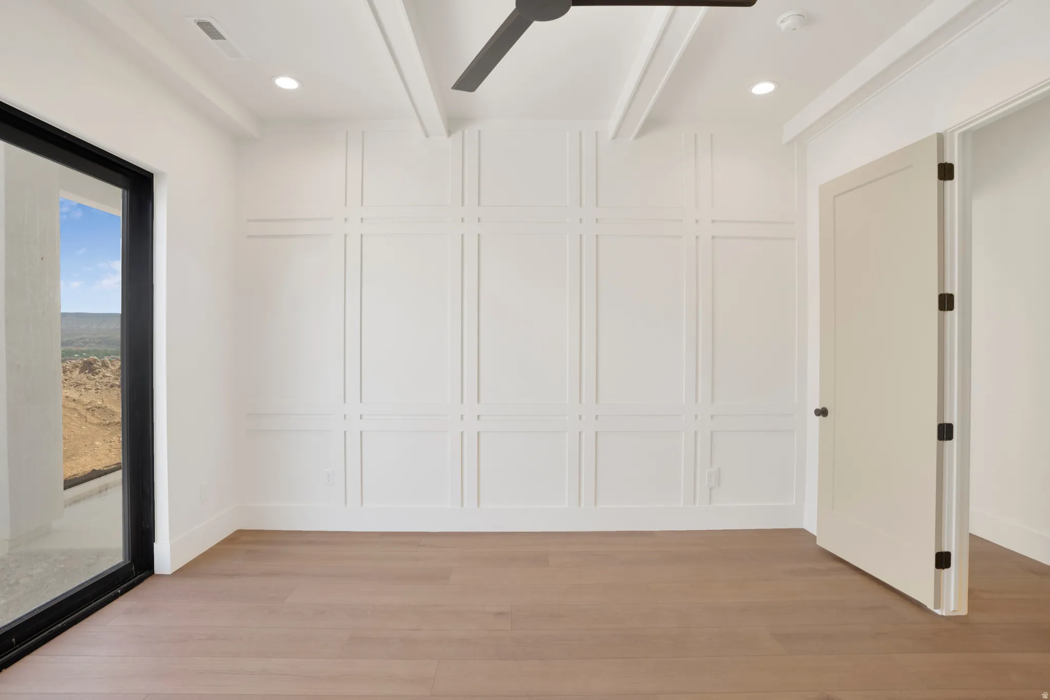 Room featuring a decorative accent wall, wood-finish flooring, recessed lighting, and a contemporary ceiling fan