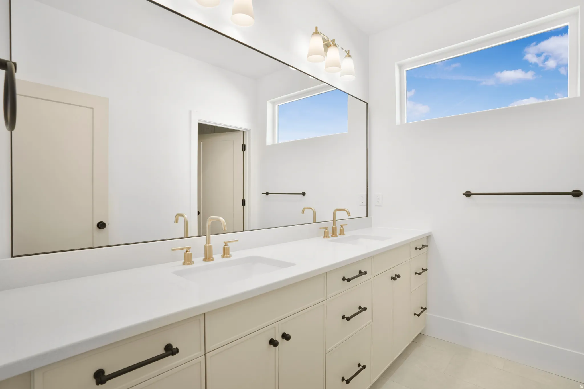 Dual vanity with integrated sinks, light countertops, and brass-tone fixtures