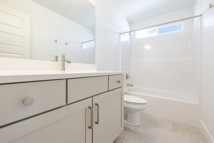 Contemporary vanity with a flat-panel cabinet, integrated sink, brushed nickel faucet, and a large wall-mounted mirror