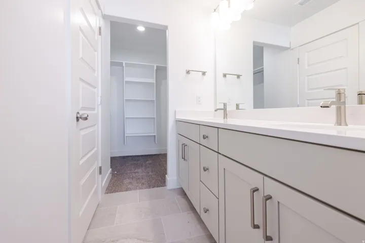 Dual vanity with light gray cabinetry, brushed nickel hardware, and white countertops