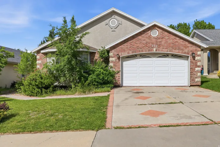 Brick and stucco exterior featuring a two-car garage with a paneled door