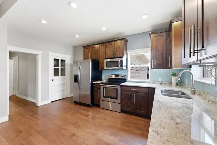 Kitchen featuring wood-finish flooring, recessed lighting, and stainless steel appliances