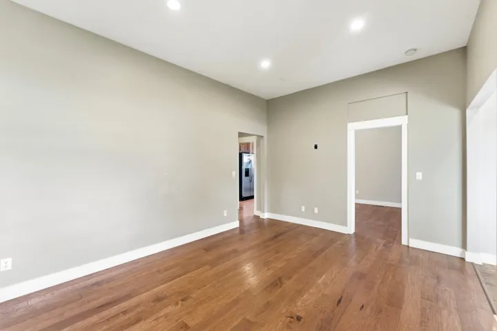 Spacious interior featuring wood-finish flooring, recessed lighting, neutral wall paint, and white trim