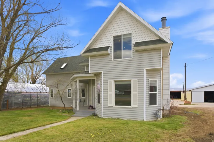 Light gray two-story siding exterior with white trim and a dark green roof