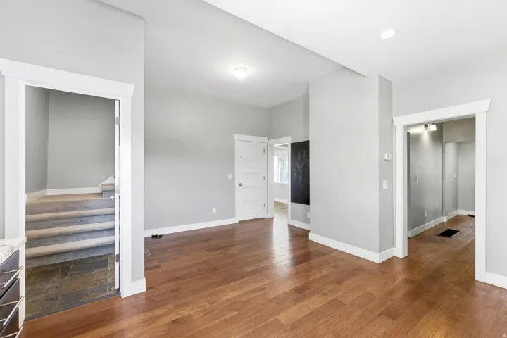 Spacious interior with wood-finish flooring, light gray wall tones, and white trim