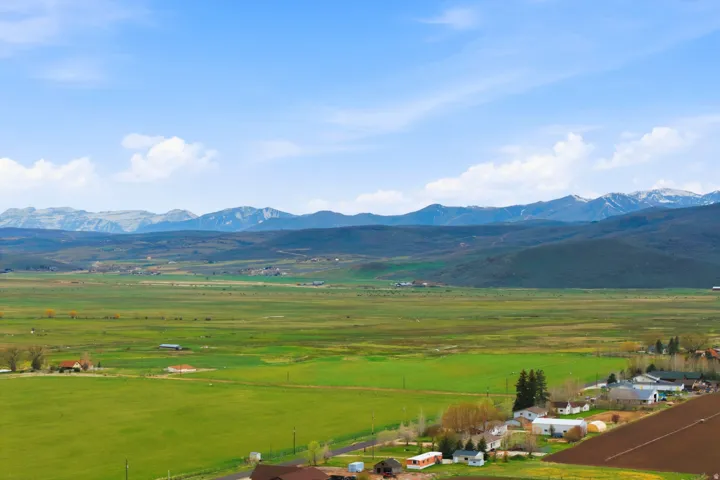 Expansive green landscape featuring distant mountain ranges with snow-capped peaks