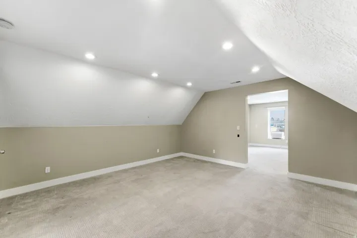 Carpeted room with recessed lighting and sloped ceilings