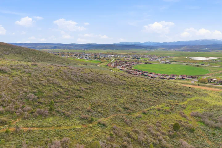 Expansive hillside property featuring natural vegetation and distant mountain ranges