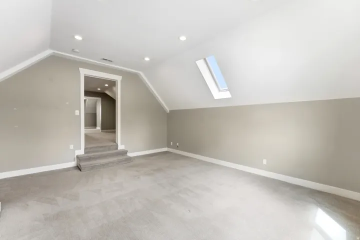 Spacious room with sloped ceilings and light gray walls