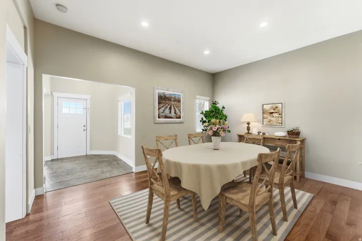 Spacious dining area featuring wood-finish flooring, recessed lighting, and a neutral wall palette