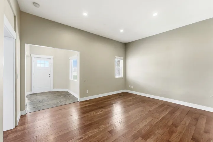 Spacious room featuring wood-finish flooring, recessed lighting, and neutral wall tones