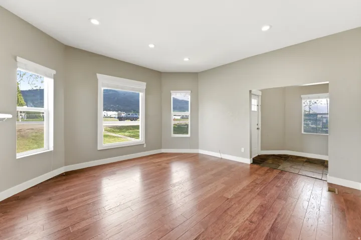 Spacious interior featuring wood-finish flooring, recessed lighting, and bay windows