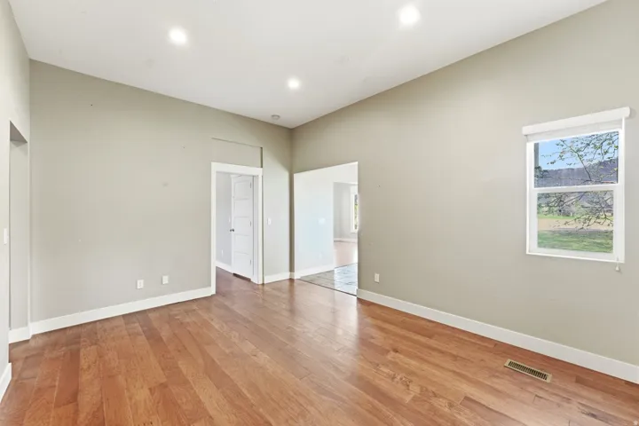 Spacious room featuring wood-finish flooring, recessed lighting, and a neutral wall color
