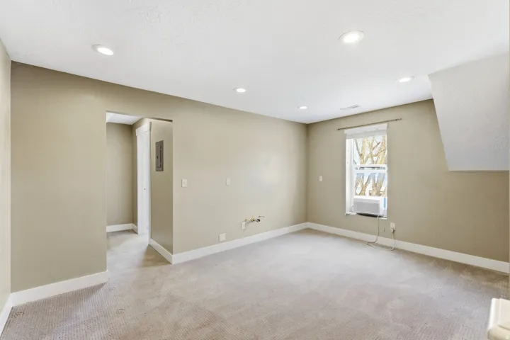Spacious room with recessed lighting, light-toned carpeting, and neutral wall tones