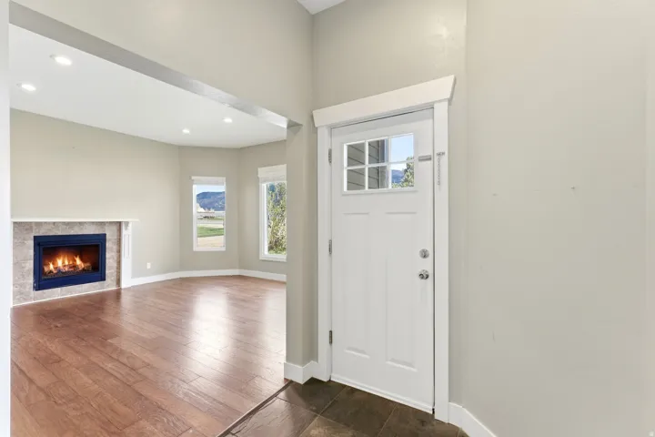 Entryway featuring a white paneled door with windowpanes, dark stone tile flooring, and light wall tones