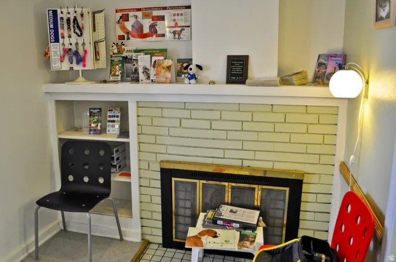 Fireplace featuring light-colored brick surround, black firebox with screen, and a white mantel