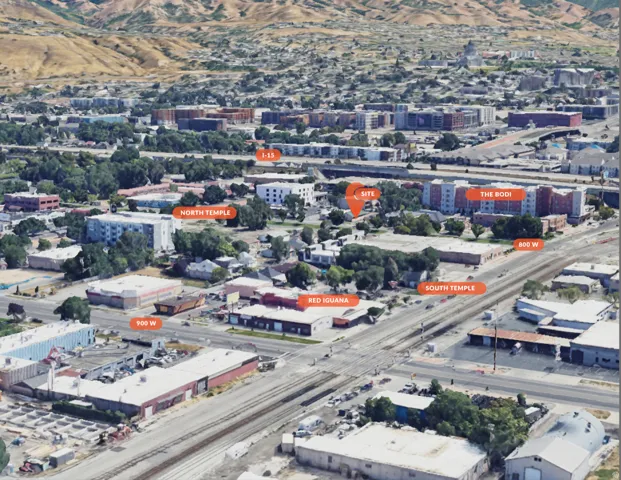 Aerial perspective showcasing an urban landscape with diverse building types, a prominent mountain backdrop, and multiple labeled roads