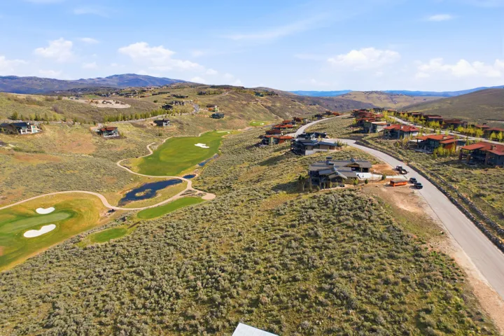 Expansive golf course community featuring multiple fairways, greens, and water features set within a mountainous landscape