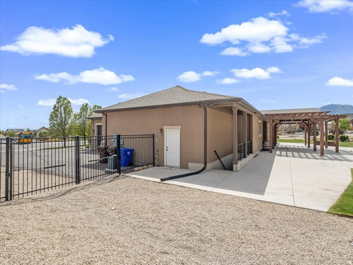 Stucco exterior with a covered porch and extended pergola