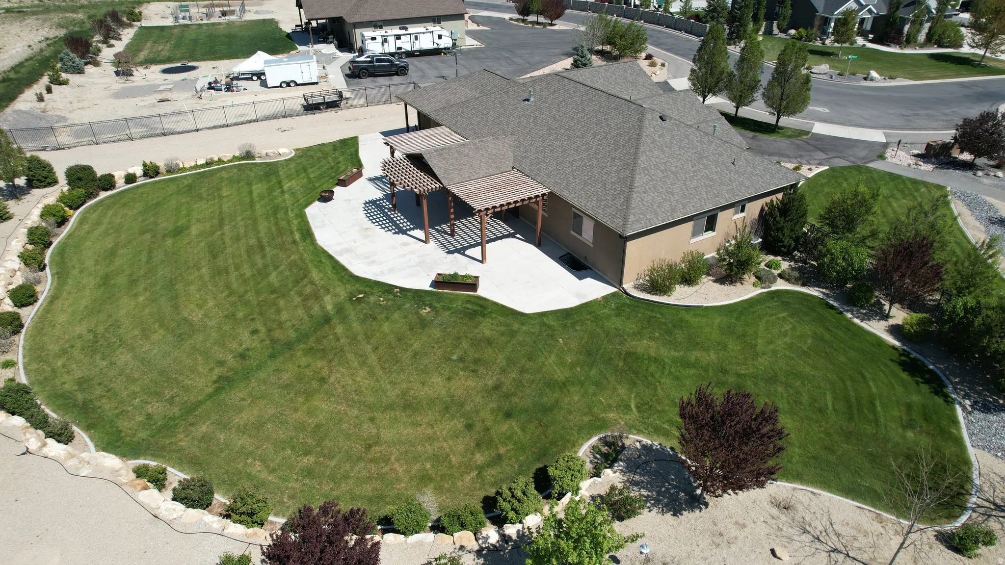 Expansive backyard featuring a large lawn, integrated patio, and two pergolas