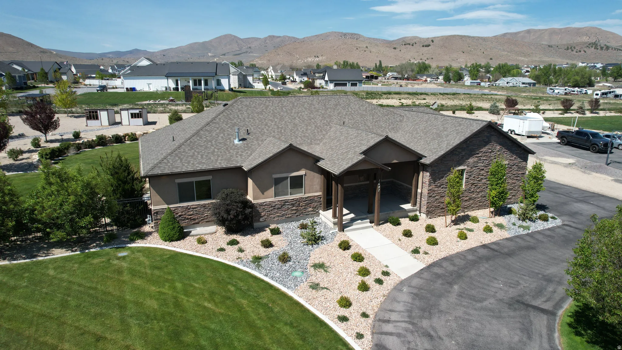 Contemporary ranch-style residence featuring a stone and stucco exterior