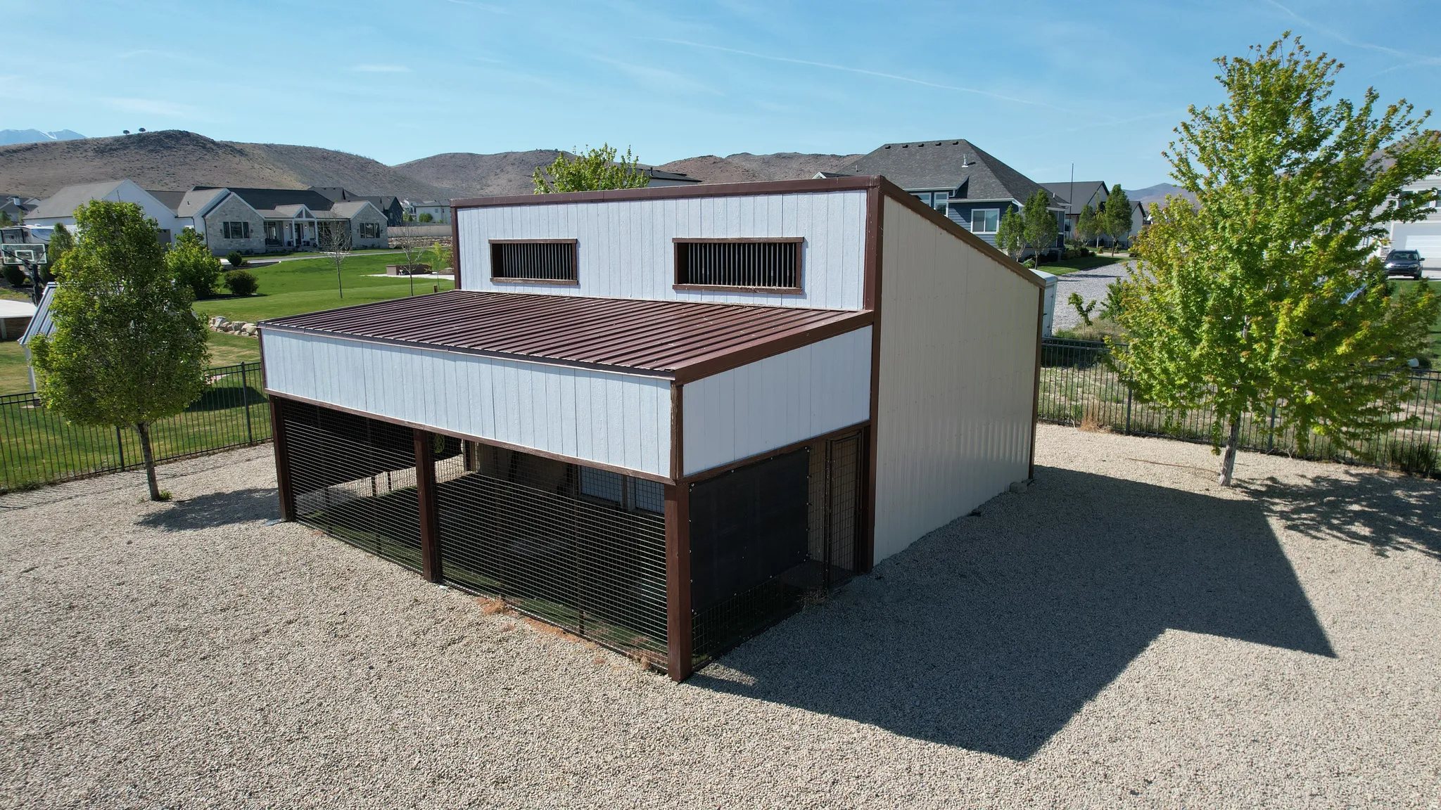 Two-story metal structure featuring a corrugated brown metal roof and white siding