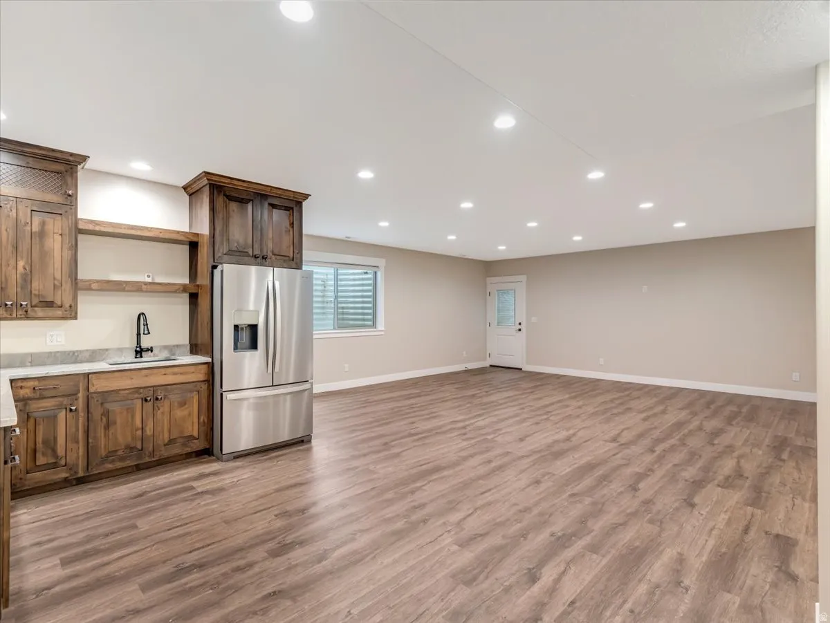 Spacious room featuring wood-finish flooring, recessed lighting, and neutral wall tones