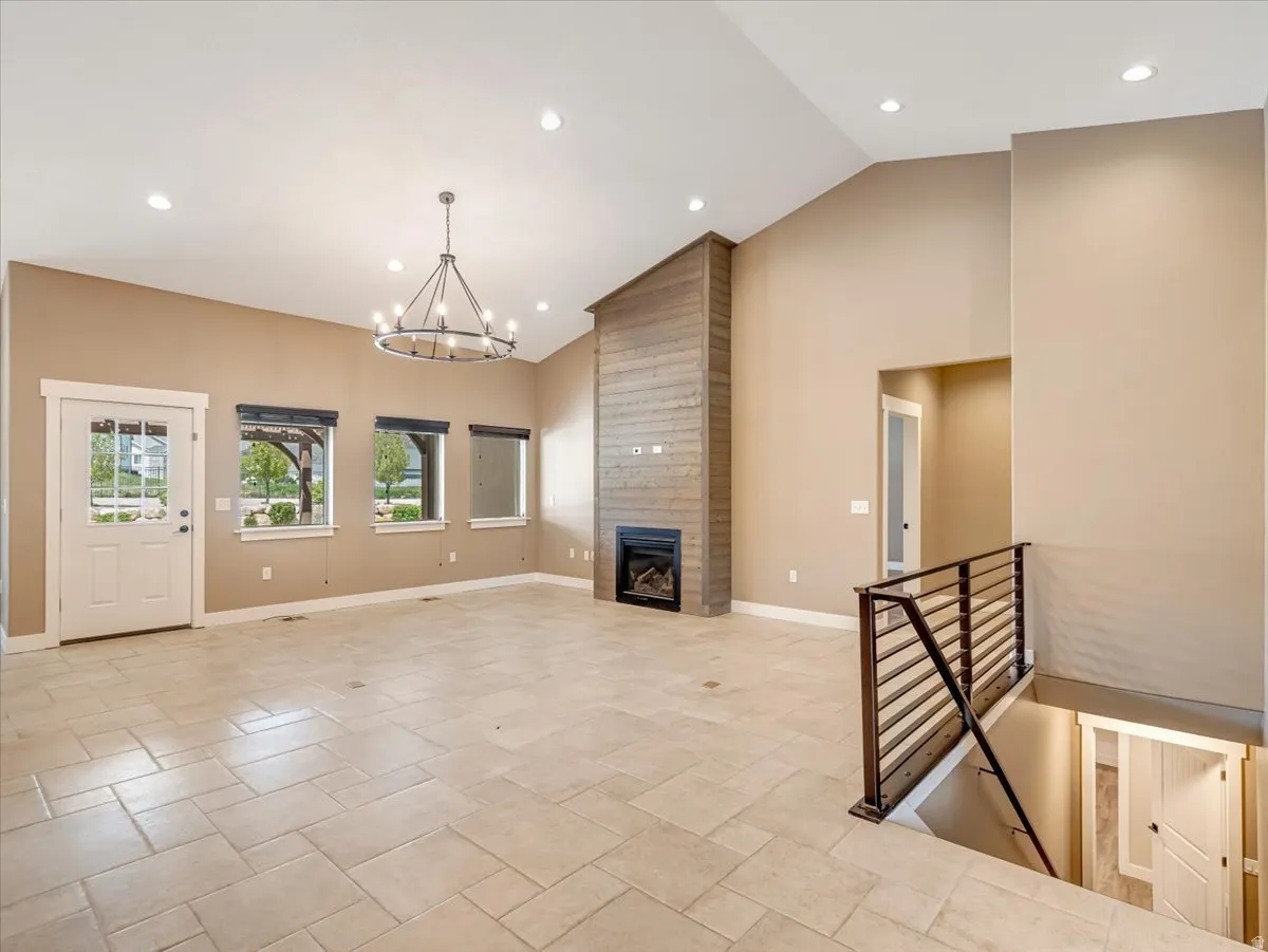 Spacious living area featuring vaulted ceilings, recessed lighting, and a modern chandelier